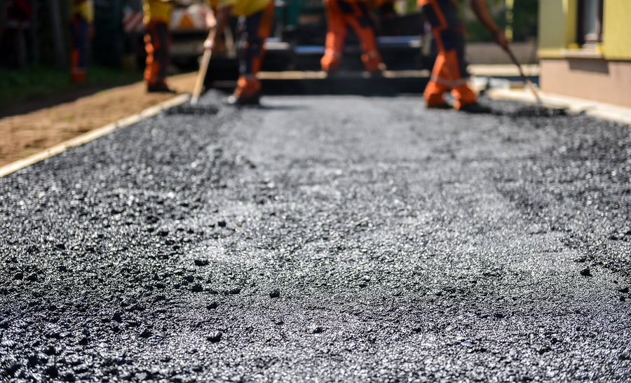 workers pouring asphalt on driveway