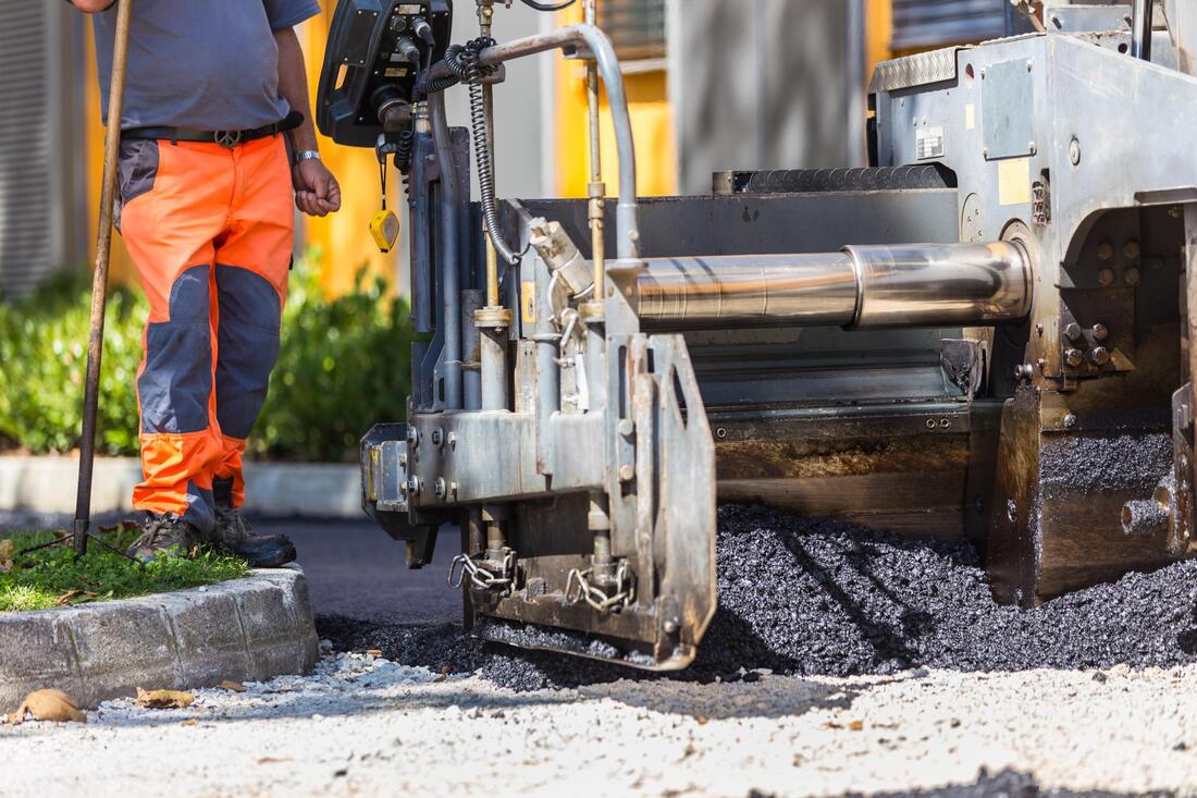 construction worker pouring asphalt