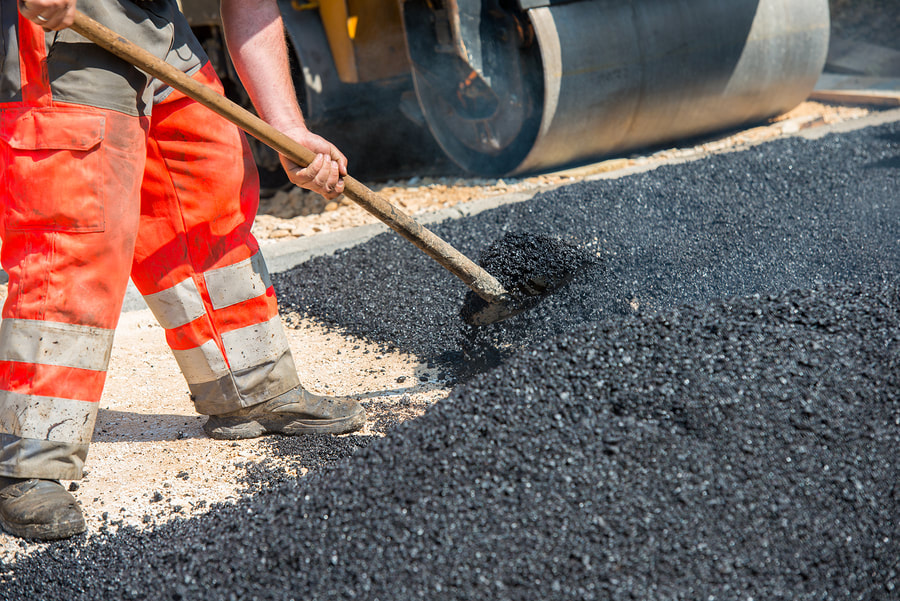worker pouring asphalt gravel